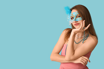 Canvas Print - Beautiful young woman in carnival mask on blue background