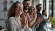 © Maksym - An executive team in a modern office, applauding and smiling as they conclude a successful presentation, their expressions a mix of pride and satisfaction.