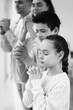 © Pixel-Shot - Little girl praying with her family at home, closeup