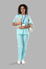 Poster - Female African-American medical intern with laptop on light background