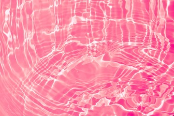 Wall Mural - Pink transparent clear calm water surface texture. Natural ripple water surface on pink background with splashes and bubbles. Summer creative layout for skin care cosmetics advertisement
