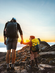family father and child with backpack holding hands hiking in mountains together exploring norway ad
