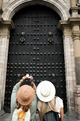 tourists in front of a door of the cathedral of lima.