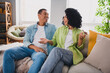 © deagreez - Photo of nice young man girl sit sofa talking communicate modern interior indoors cozy daylight apartment living room
