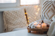 Cozy corner for home meditation, relaxation, detention. Aroma reed diffuser, aromatic burning candles. Concept of wellbeing, wellness, pleasure, aromatherapy. Apartment room decor, house design