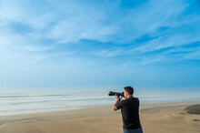 Travel Photographer At Work On A Tranquil Beach