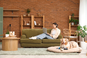 Poster - Pretty young woman with laptop and cute Australian Shepherd dog at home