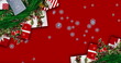Festive scene: Red background, snowflakes, gift cards, greenery, decorations