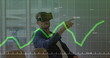 Caucasian male instructor wearing virtual reality headset pointing at graph