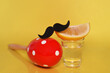 Tequila shot with mustache and red maracas on yellow background