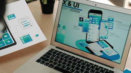 Panorama video of startup UX developer or company employee using laptop design user interface or UI prototype for mobile application or website software with software display on smartphone. Synergic