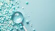 © Barbara Taylor - inspecting capsules and pills, small blue and white spheres, with a magnifying glass, copy space