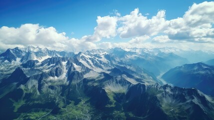 Wall Mural - Amazing view of snow-capped mountains from above. The peaks of the mountains are covered in snow, while the valleys are green and lush.