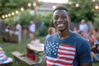 African American young man posing with USA t-shirt for Independence Day celebrations in the backyard with neighborhood