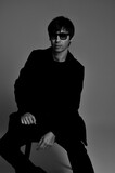 Fototapeta Dinusie - homem modelo com óculos escuros em retrato da moda em estúdio 