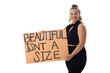 Caucasian young female plus size model holding poster, smiling brightly on white background
