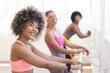 © Wavebreak Media - Three diverse women are stretching at barre in a bright studio, copy space
