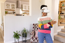 African American Young Woman Dances At Home In Living Room With VR Headset At Home, Copy Space