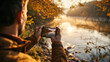 Person capturing autumn river scene with smartphone during sunset. Outdoor photography with copy space. Adventure and nature exploration concept. Design for travel blog, poster, background.