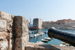 Ancient cannon points out across Dubrovnik habour from within walls of ancient city.