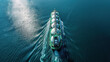 Aerial view of an oil tanker with gas tanks sailing on the sea in white and green colors. The cargo ship is carrying natural fuel to open up new markets