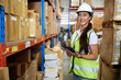 © offsuperphoto - portrait worker working on tablet and looking at cardboard box on shelf in warehouse storage