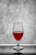 A glass of red wine on a gray background