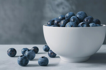 Wall Mural - fresh blueberries in a bowl on a white table against a gray background