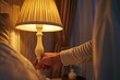 Male hand turn off the light on torchiere lamp in bedroom. Saving electricity energy at night. Switch off lighting equipment for bedtime.