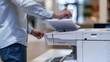 © sorin - Businessman using multifunction printer in office for document copying and printing