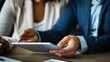 © Attasit - sales representative using a tablet to close a deal with a client in a stylish office setting