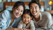© aekkorn - Happy Asian family laying on bed smile.