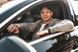 © fotofabrika - Young smiling man sitting in a car with open window