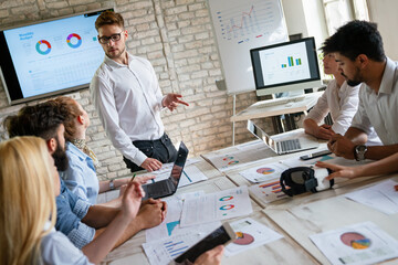 Wall Mural - Team of young creative marketing business experts brainstorming during work at startup office