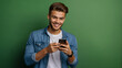 Trendy and cool young man smiling and holding his smartphone on a clean background
