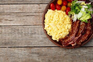 Wall Mural - Breakfast plate . Scrambled eggs , bacon , cherry tomatoes and salad