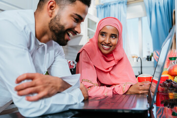 Wall Mural - Happy middle eastern couple wearing traditional arab clothing at home