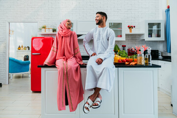 Wall Mural - Happy middle eastern couple wearing traditional arab clothing at home