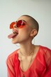 Woman with striking red sunglasses and tongue out in a playful yet fashionable pose.