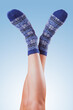 legs in christmas socks on blue background