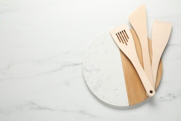 Poster - Board with different wooden spatulas on light marble table, top view. Space for text