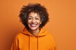 © Markus Schröder - Portrait of a grinning afro-american woman in her 60s wearing a thermal fleece pullover in solid color backdrop