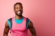Portrait of a cheerful man in his 30s wearing a lightweight running vest in front of solid pastel color wall