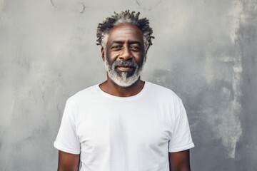 Portrait of a cheerful afro-american man in his 50s donning a trendy cropped top in front of bare concrete or plaster wall