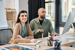 © Bliss - A man with myasthenia gravis and woman engrossed in work, sitting at a desk in front of a computer in a corporate office setting.