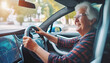 Gray haired elderly woman driving a modern electric car with monitor. Active old age. Transportation and technology. Smart device, internet and the future. 