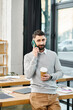 © Bliss - A man in a business setting holds a cup of coffee while talking on a cell phone.