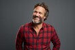 © Markus Schröder - Portrait of a satisfied man in his 40s wearing a comfy flannel shirt on blank studio backdrop