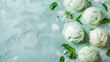 Scoops of mint ice cream with fresh mint leaves on a minty background.