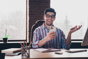 Poster - Photo of young man corporate worker speak video call smart phone wear striped shirt modern office home indoors